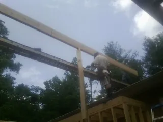 Carpenter setting a ridge beam over a new addition frame — Ice Dam Removal by Roofing Brothers in Wrens