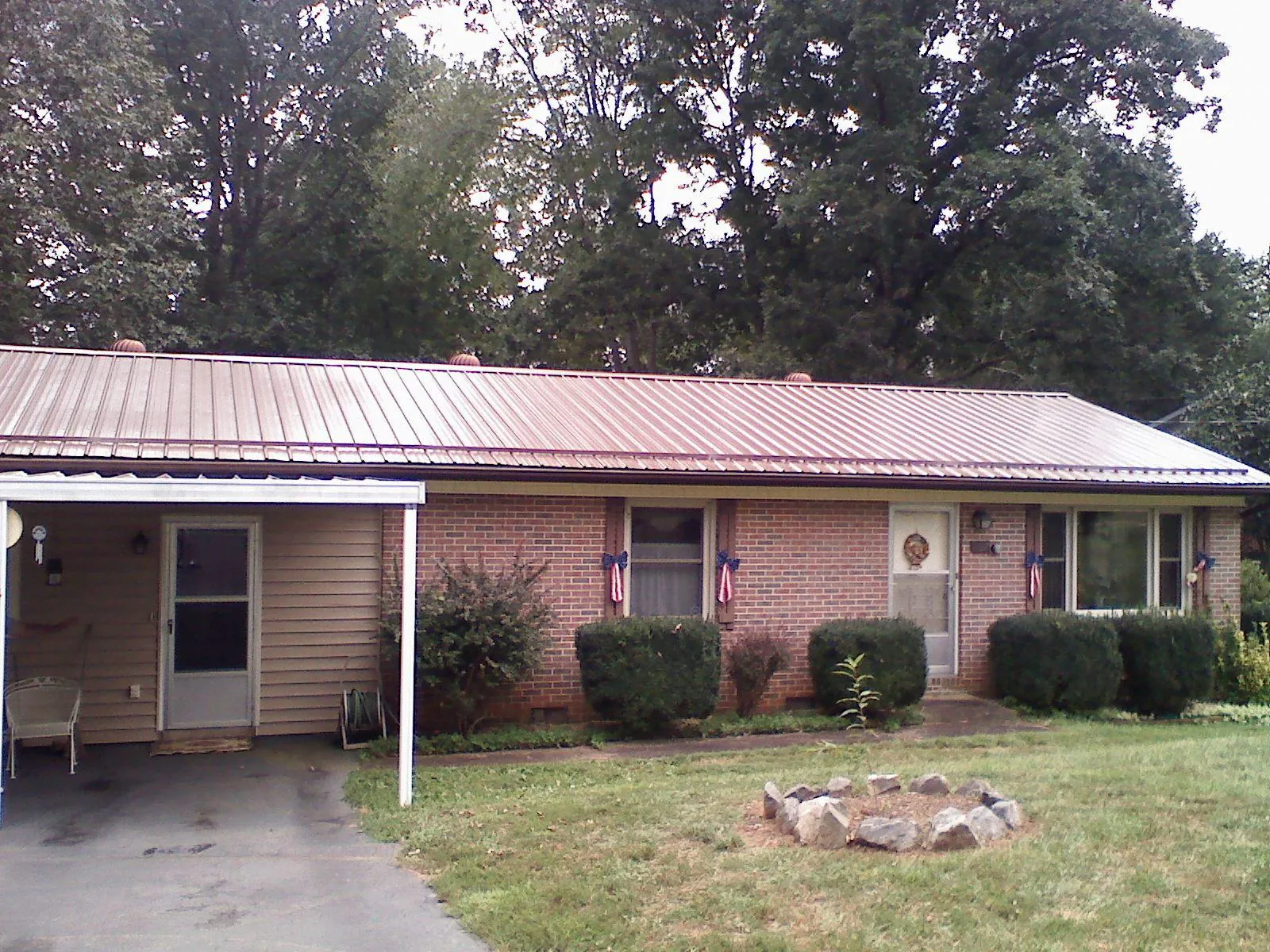 Bronze metal roof and carport on a brick ranch home — Roof Repair work by our crew in Wrens